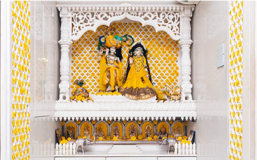 A pooja room in a home with Idols of Radha Krishna