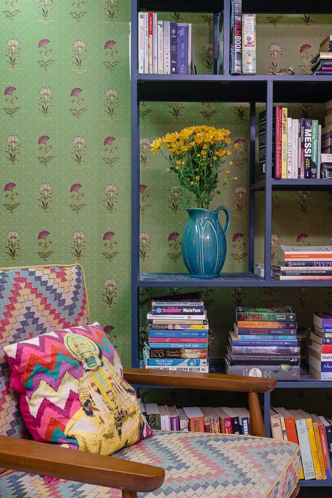 Huma’s reading corner with foral wallpaper by Nilaya x Good Earth behind a colourful bookshelf and armchair