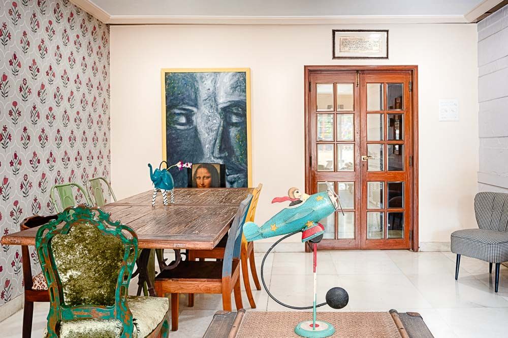Quirky dining area with chairs of different styles and sizes and eclectic art pieces