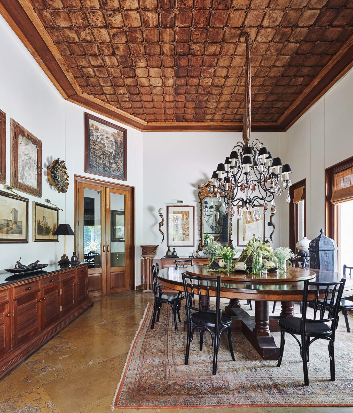 Tarun Tahiliani´s dining room with a circular table, Irani cafe chairs, a French gilded mirror and wooden ceiling - Beautiful Homes