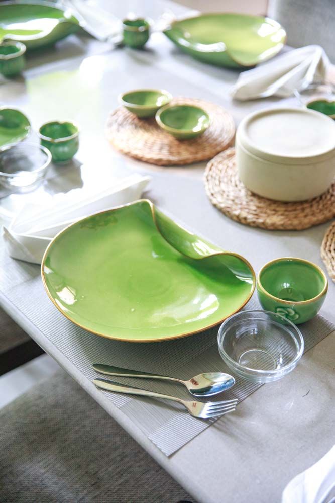 A green ceramic plate and bowl placed on a white table