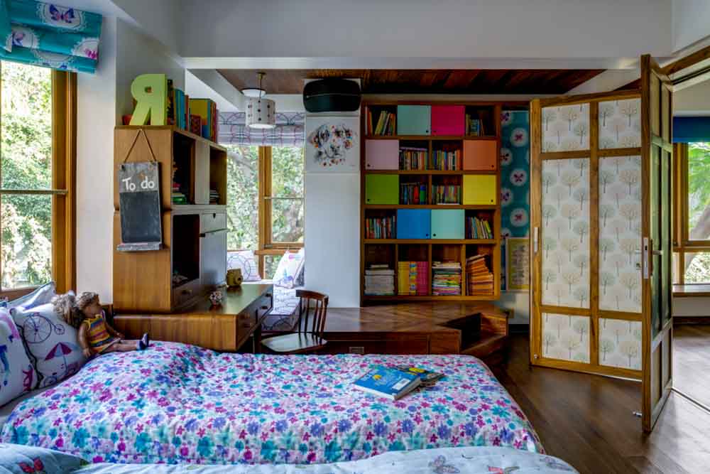 A bedroom with a reading nook ,bed and a stage