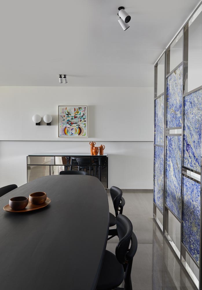 Black dining table & chairs to contrast with grey floor & blue screen in the dining room - Beautiful Homes