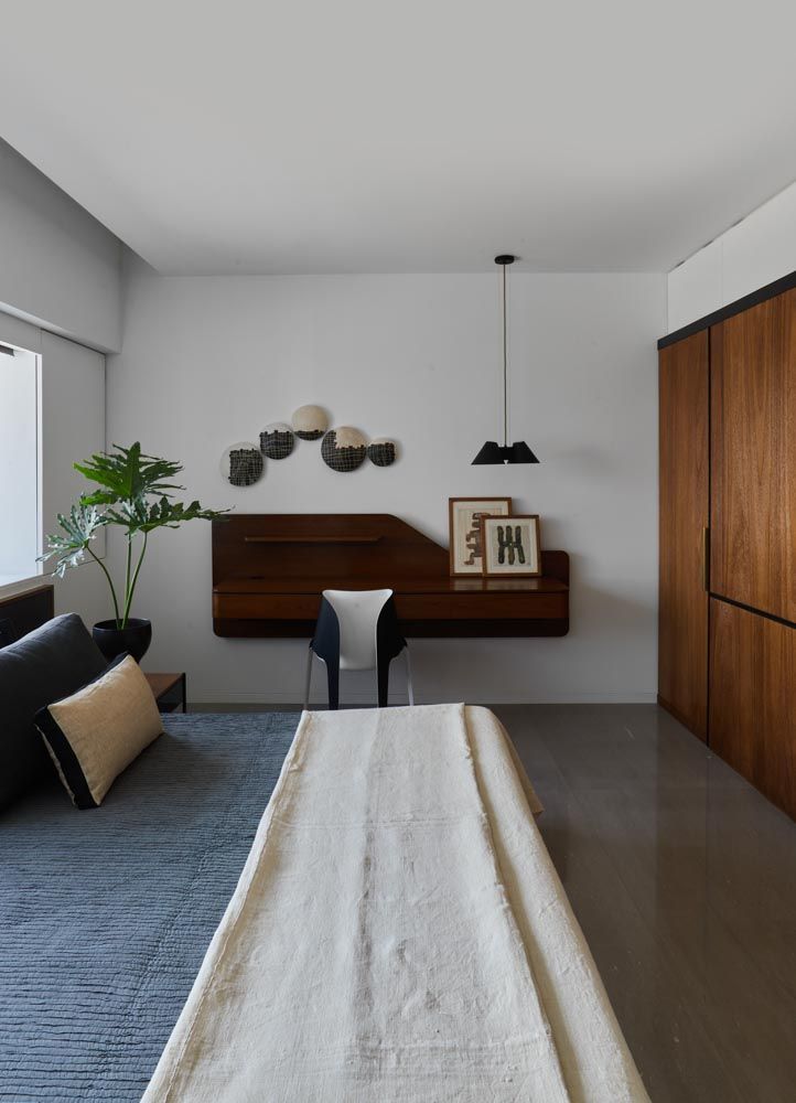 Bedroom interior design with ceramic artwork on the wall & walnut panelling opposite the bed- Beautiful Homes