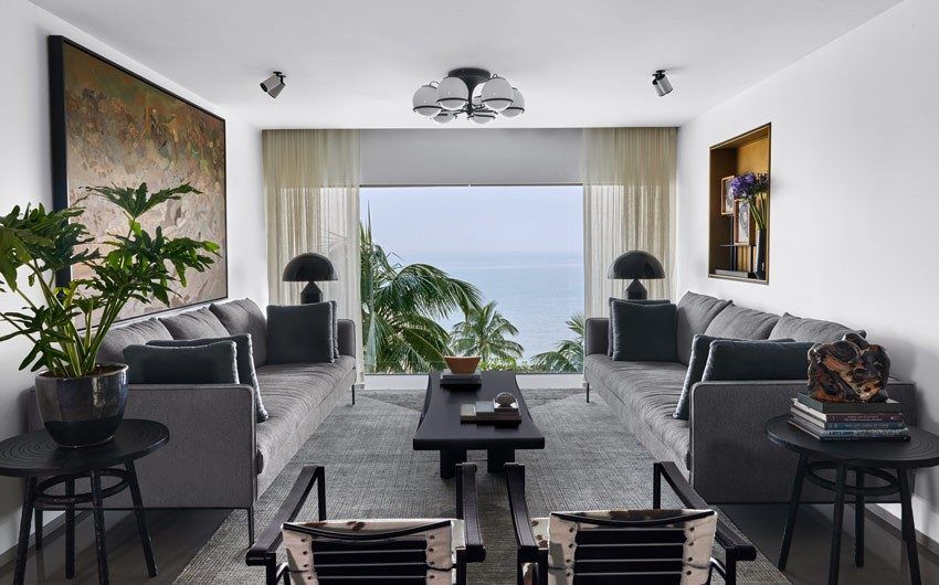 Symmetrical arrangement of sofas & chairs in the sea-facing living room - Beautiful Homes