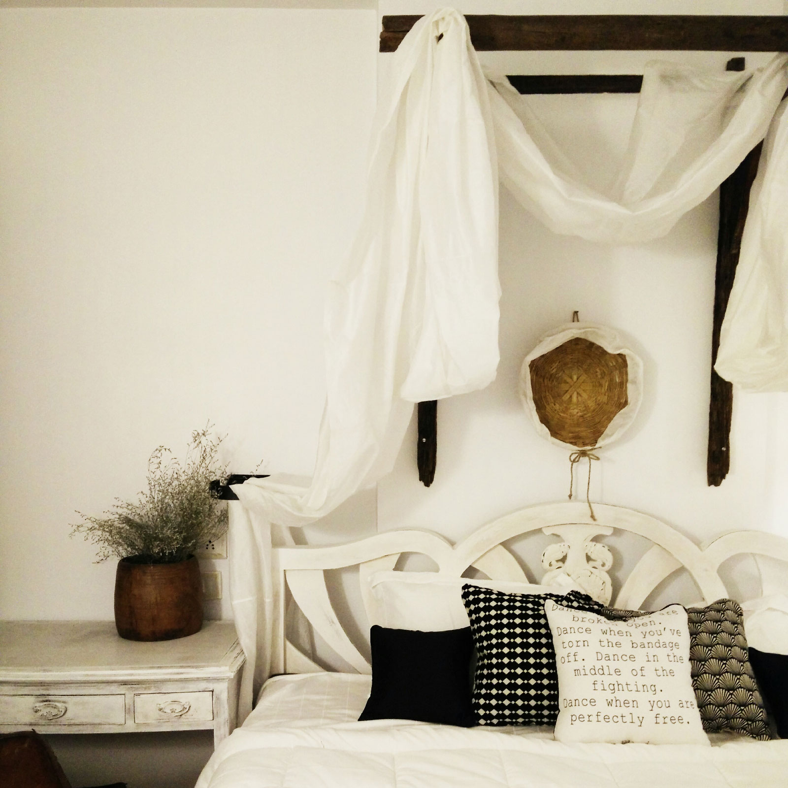 A cosy bed with several cushions and cane elements for a touch of the rustic charm – Beautiful Homes