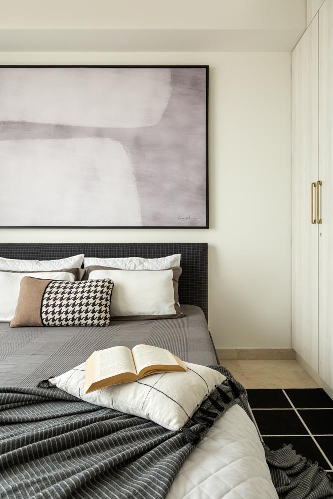 Bedroom design has a bold black & white tone with an oversized wall art - Beautiful Homes