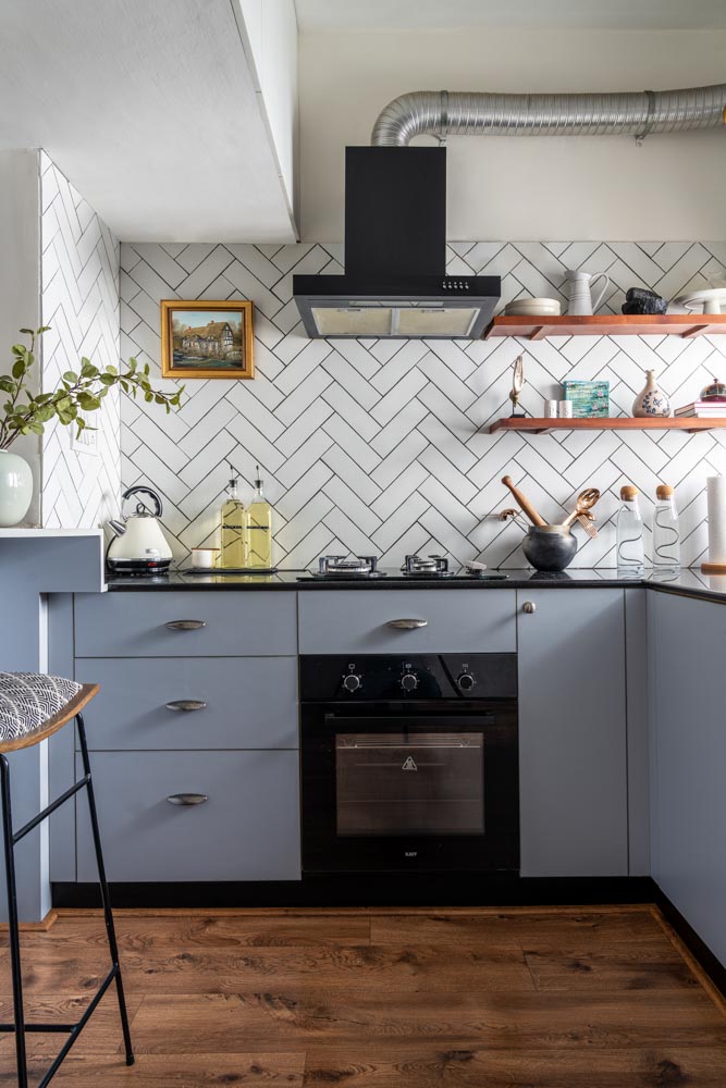 Kitchen features tiles in a herringbone pattern & floating teakwood shelves - Beautiful Homes