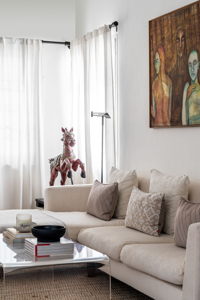 The living room has horse sculpture, reading light & wall art for décor - Beautiful Homes