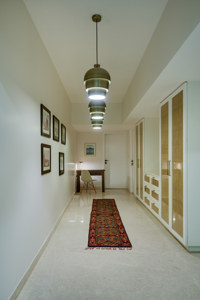 Interior design of the hallway has a cane & glass closet & brass pendant lights - Beautiful Homes