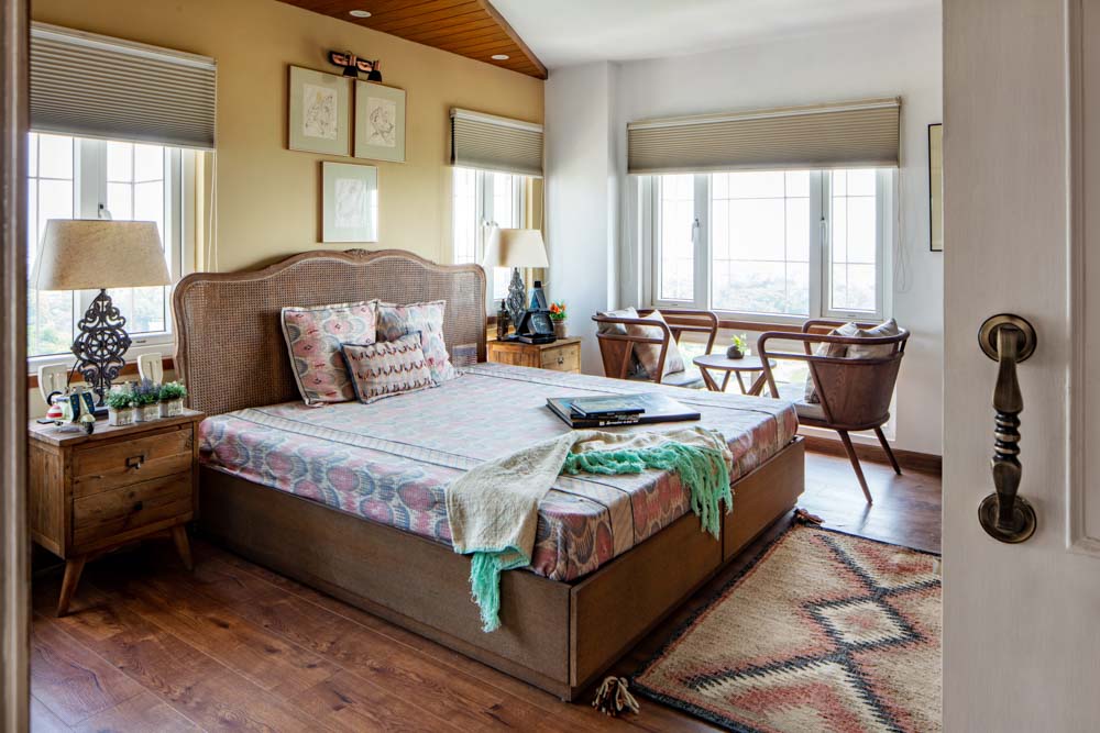 Primary bedroom design has oversized windows & solid wood furniture with contrast bedroom decor - Beautiful Homes