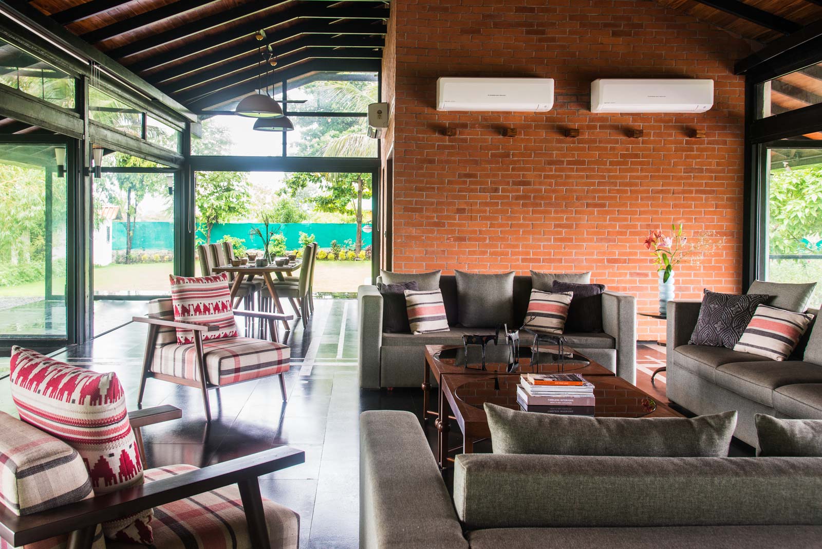 Double bed in the forefront of a wall with two big windows and storage space