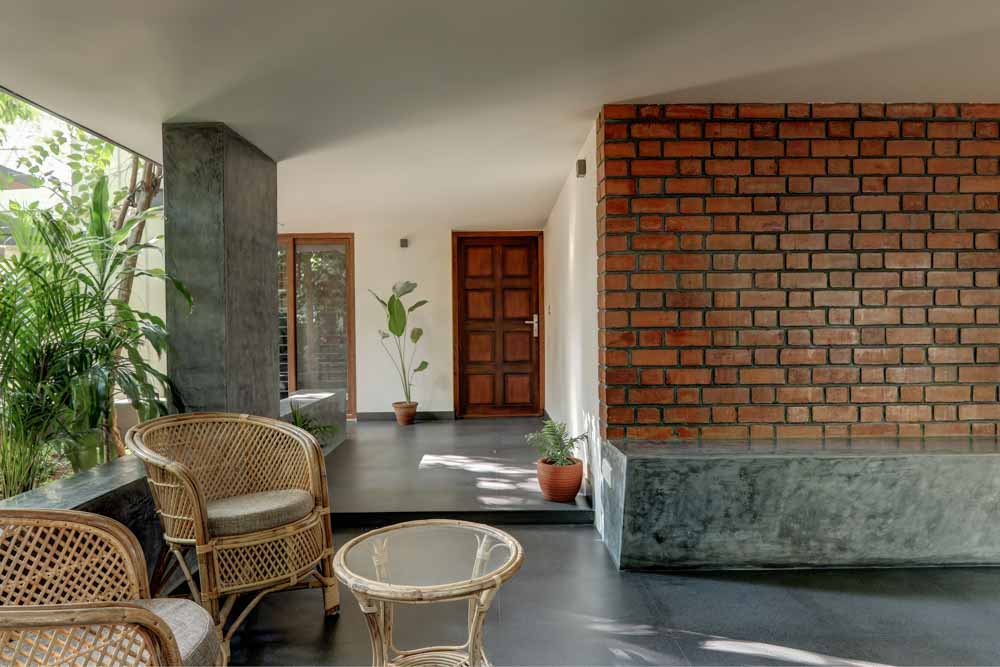 A concrete passage in a home with cane furniture - Beautiful Homes