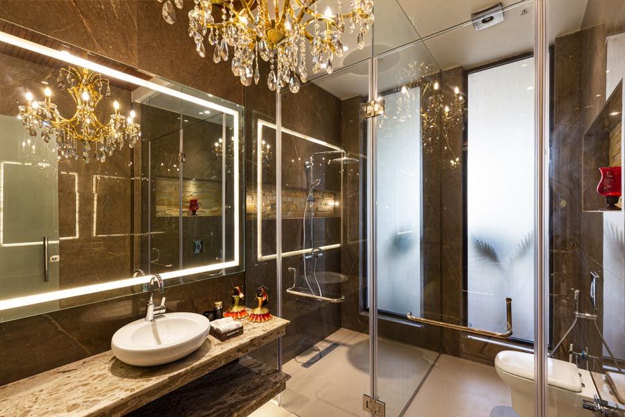 A luxurious bathroom with a chandelier and a large mirror - Beautiful Homes