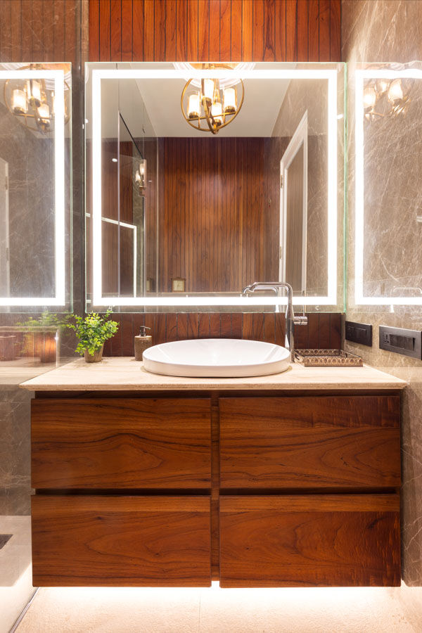A washbasin in a bathroom with wooden cabinets and a white wash basin - Beautiful Homes