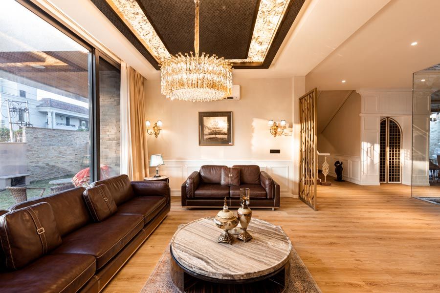 A living room with a leather fabric sofa and a chandelier - Beautiful Homes