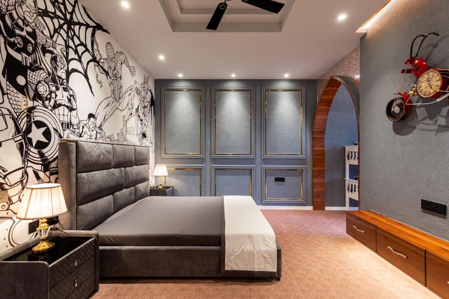 A bedroom with a bed with a grey tufted headboard and a wall with an artwork of superheroes - Beautiful Homes