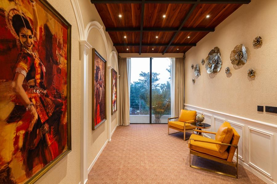 A room with a wall filled with large artworks of traditional Indian dancers - Beautiful Homes