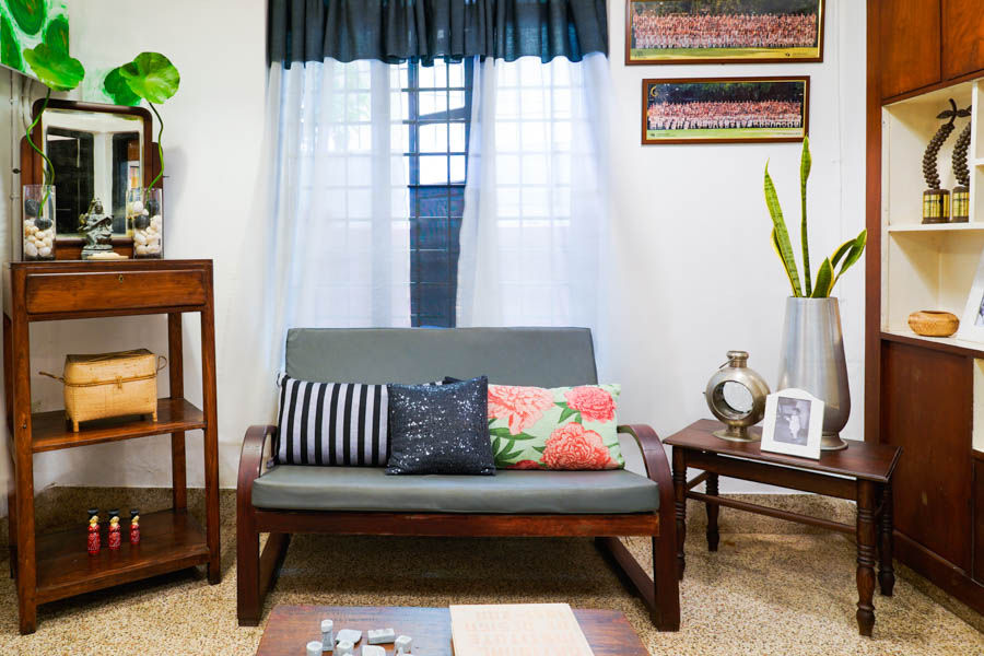 A living room with a wooden sofa next to a window - Beautiful Homes