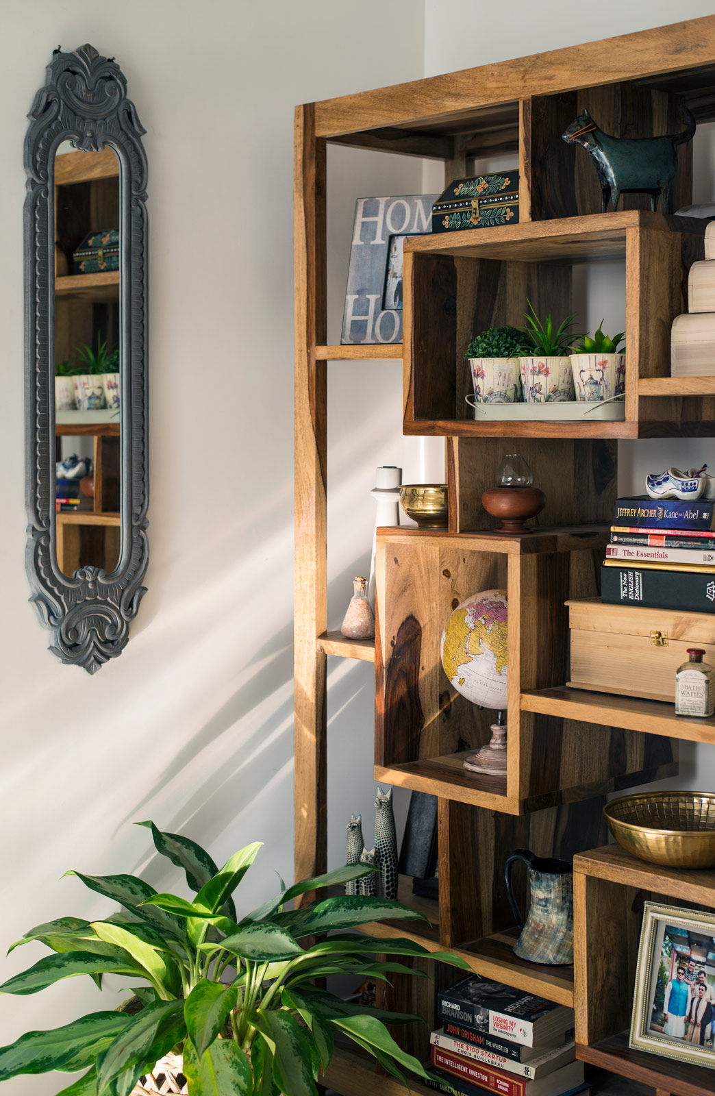 The bookshelf in the living room is peppered with curios from Yogesh’s travels, photo frames and her favourite books - Beautiful Homes