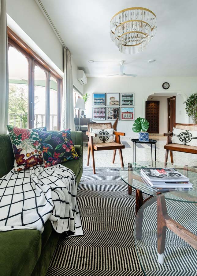 Living room with a green sofa which has a throw on, a couple of Chandigarh chairs, green sofas and a centre table - Beautiful Homes