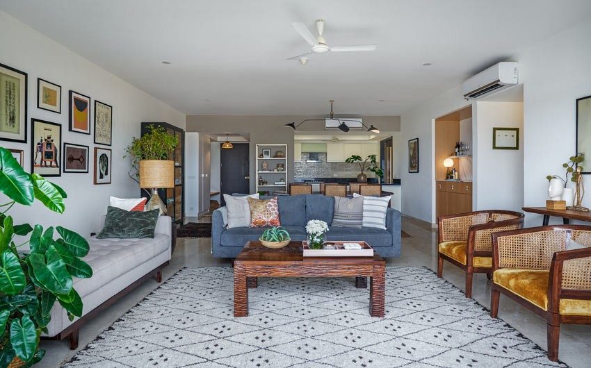 Living room with a blue sofa, two rattan chairs and a grey bench