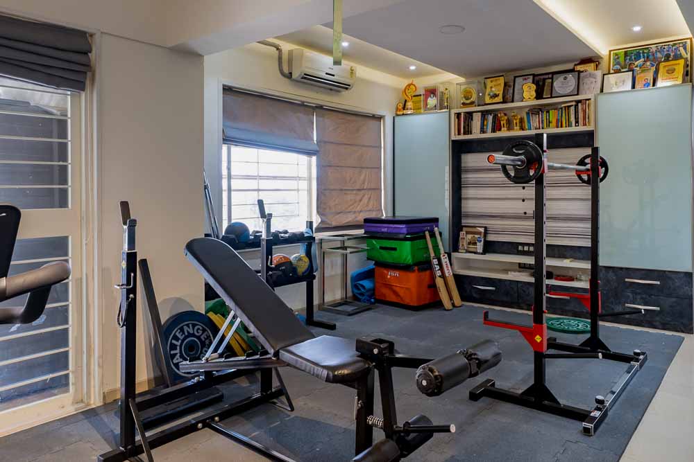A home gym made at the corner of the living room with essential gym equipment's & foam flooring - Beautiful Homes