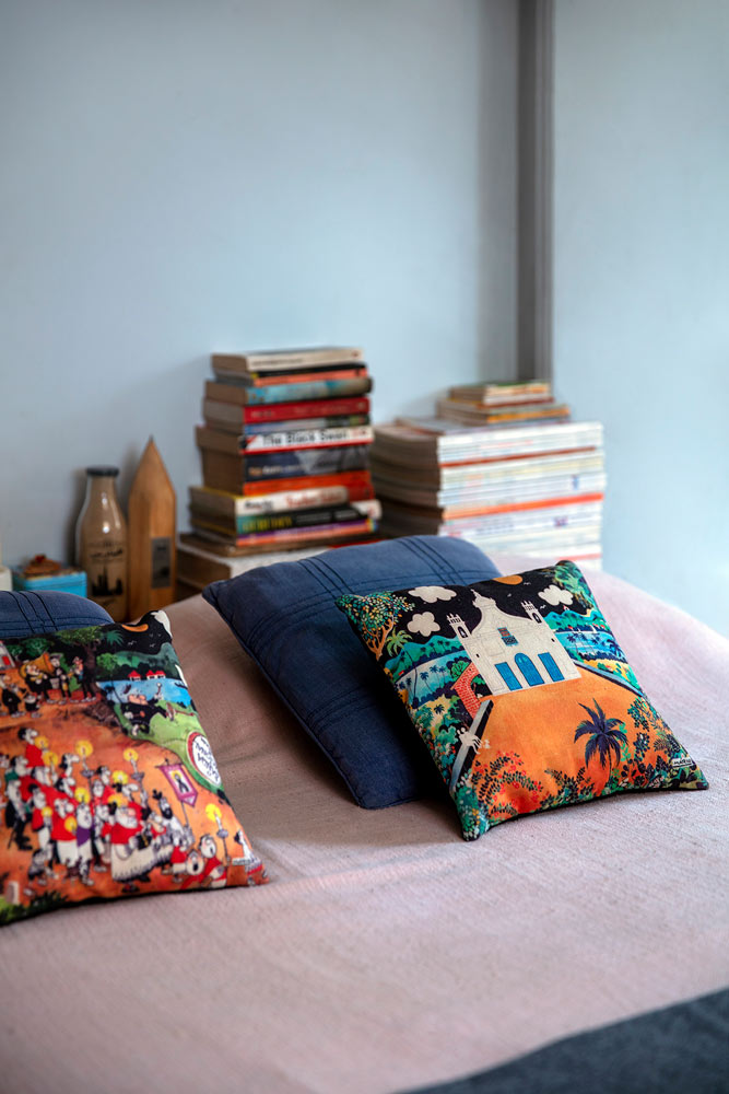 Mario Miranda cushion covers from Goa make up the bed linens in this bedroom design - Beautiful Homes