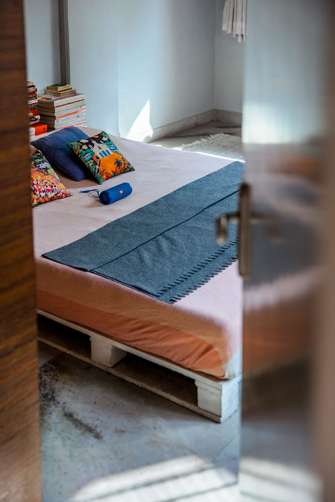 Recycled cargo pallets strategically placed to create the frame of the bed in this bedroom inteiror design - Beautiful Homes