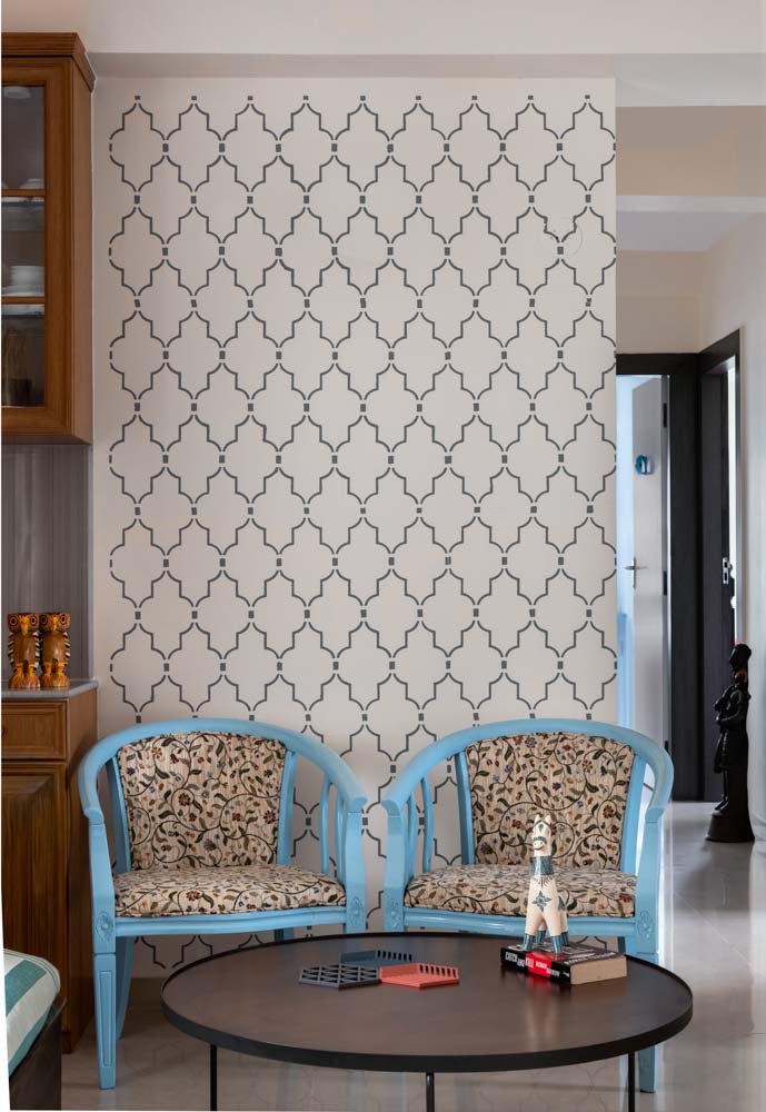 Stenciled wall design for living room that offers a backdrop to curved accent chairs - Beautiful Homes