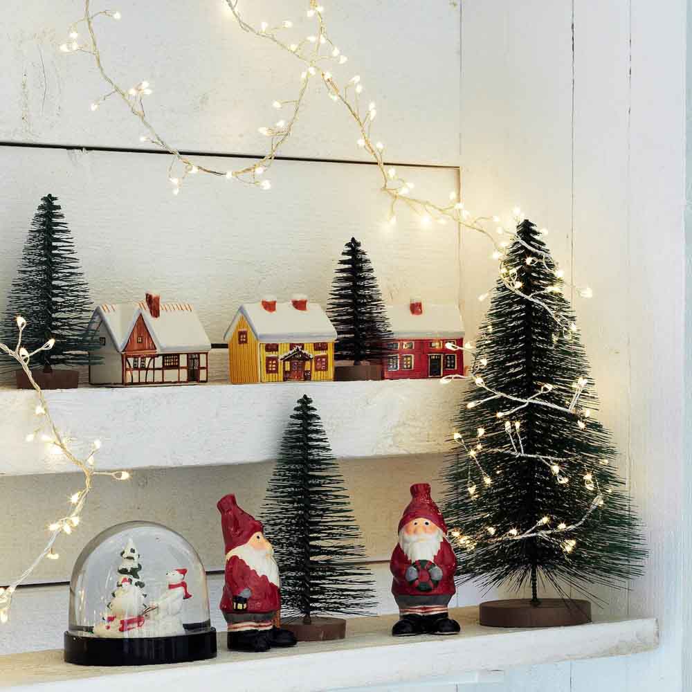 Christmas nook design idea with wooden toys, houses, miniature trees and lights for children - Beautiful Homes
