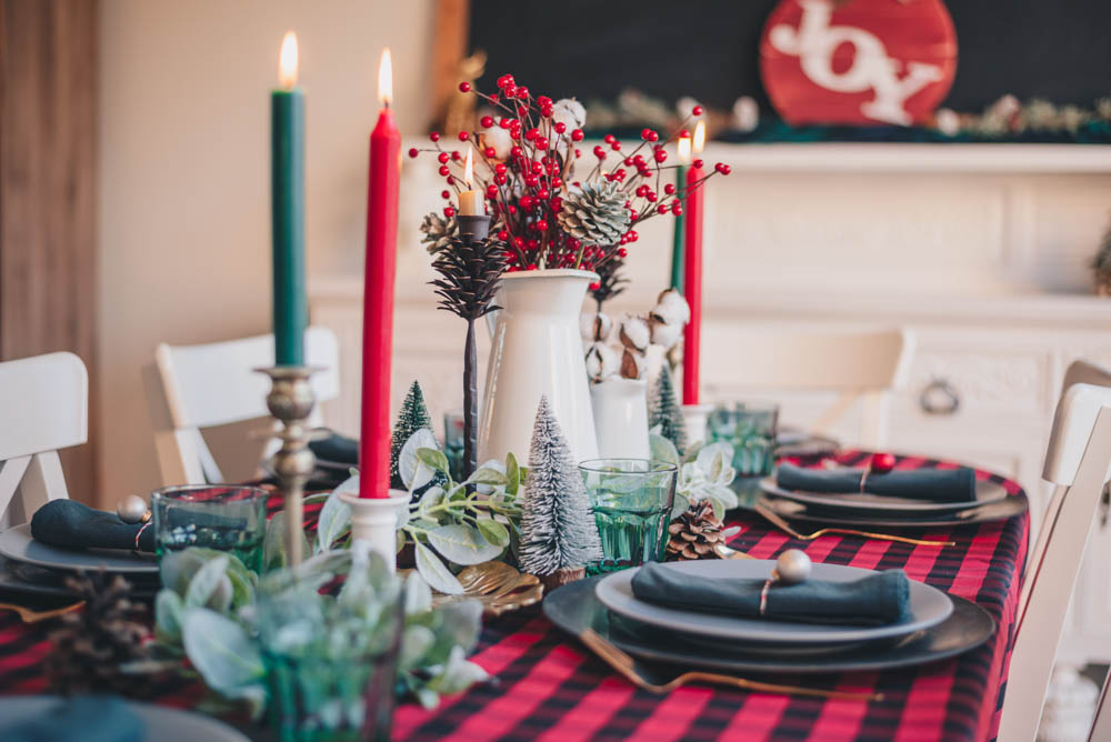 Dining table with a red and black checkered table cloth and a christmas setting