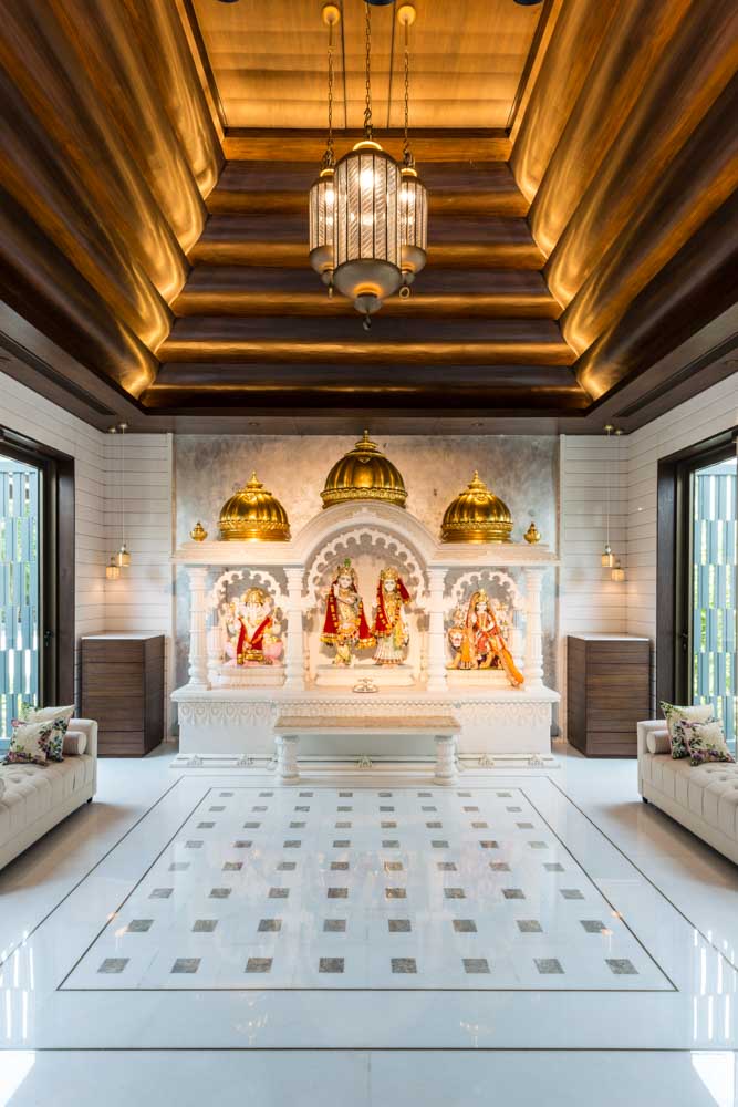 Pooja Room Design For With A Grand Tiered Wooden Ceiling, Sleek Marble Floors & Clear Glass Walls  - Beautiful Homes