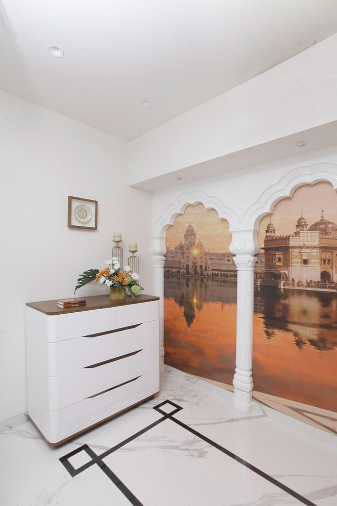 Pooja Room Design With Art Work Across A White Wall- Beautiful Homes