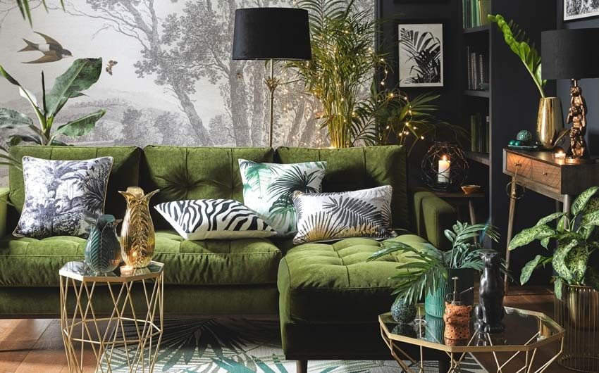 A living room with a green L-shaped sofa, white cushions, planters, and a small lights - Beautiful Homes