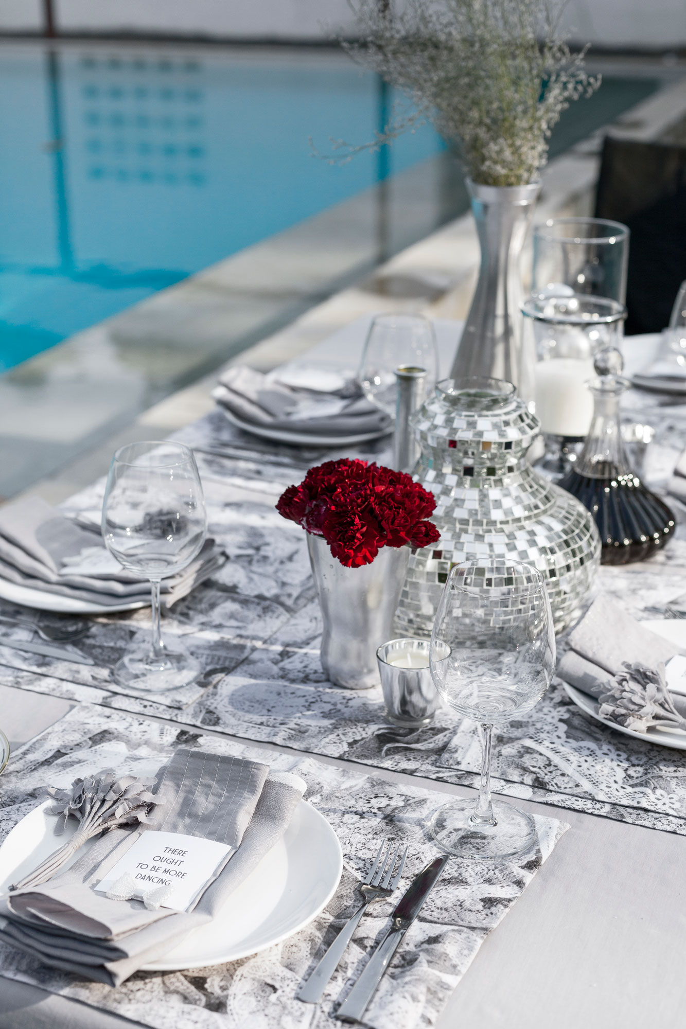 A table setting with a mix of shiny silver and pristine white - Beautiful Homes