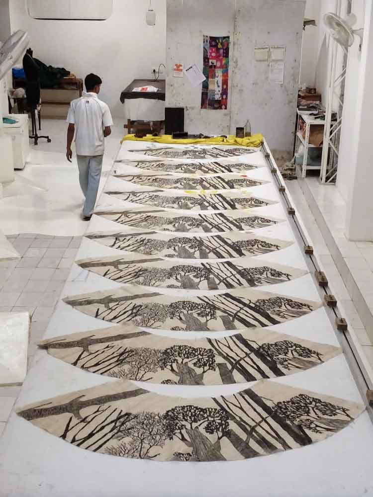An artwork in progress on a large surface at a studio