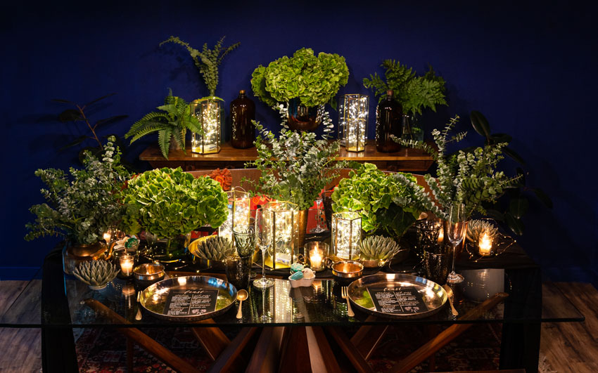Dining table decorated with dark tones and plants for Christmas