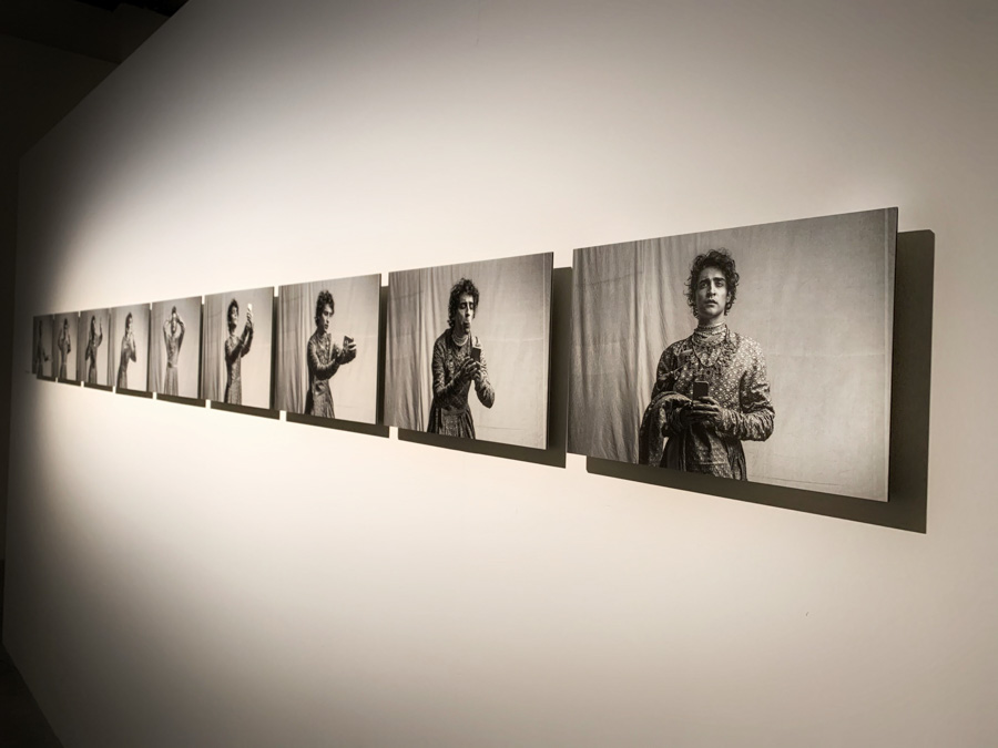 A series of photographs of a man taking pictures of himself with his phone hung on a wall next to each other