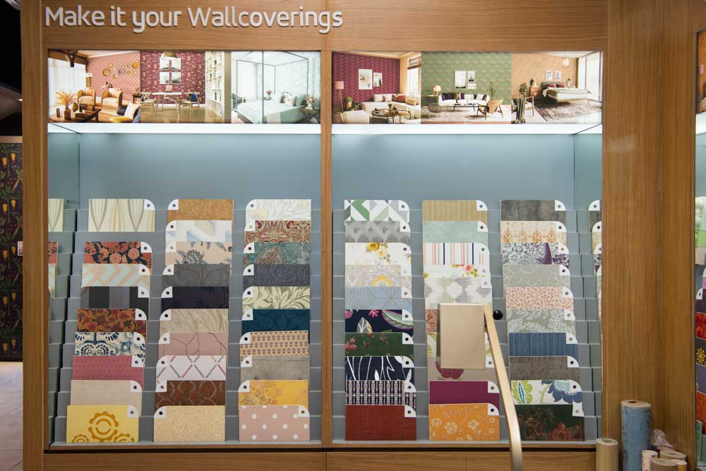 Samples of different wall coverings placed on a wooden rack