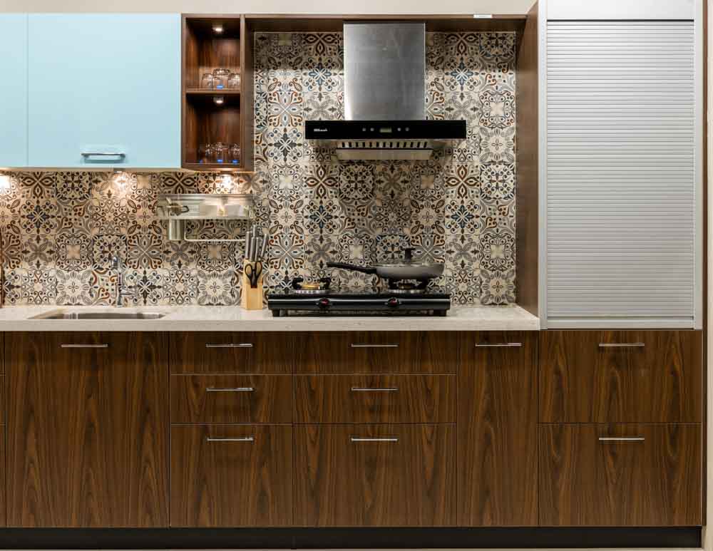 A kitchen with floral tiles used as a backsplash