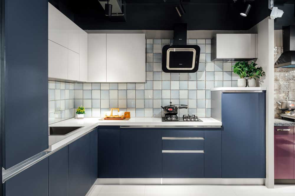A kitchen with blue cabinets and chequered tiles on the backsplash
