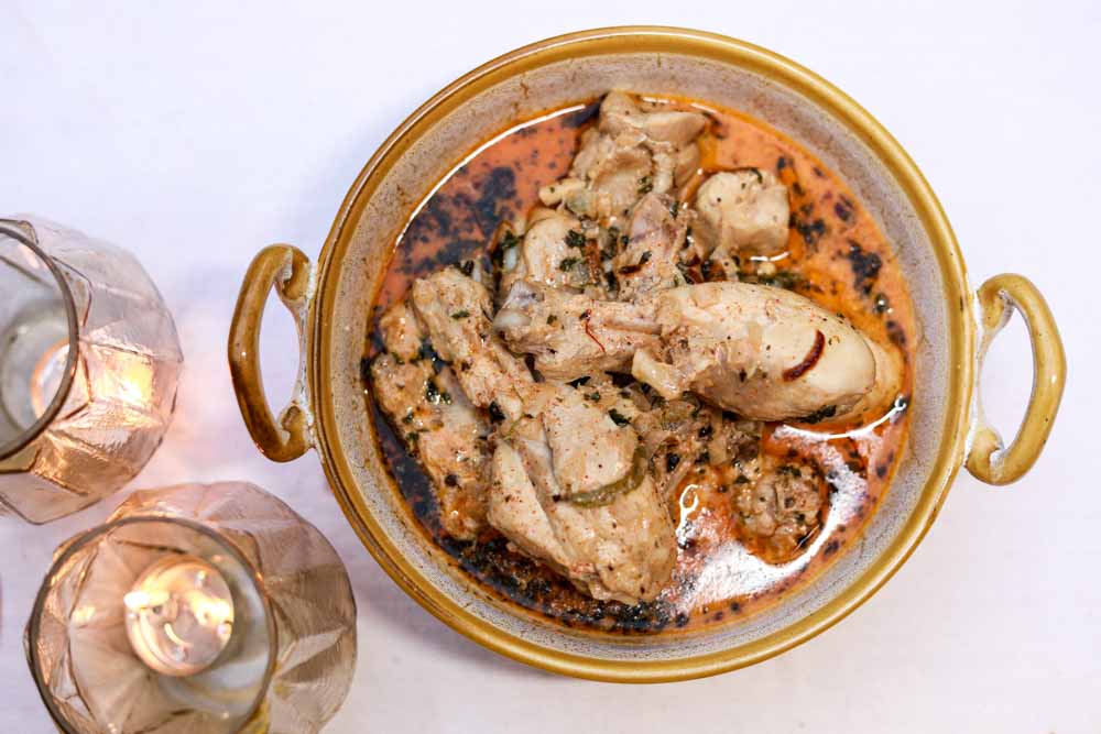A bowl of Chicken Malai curry placed on a surface