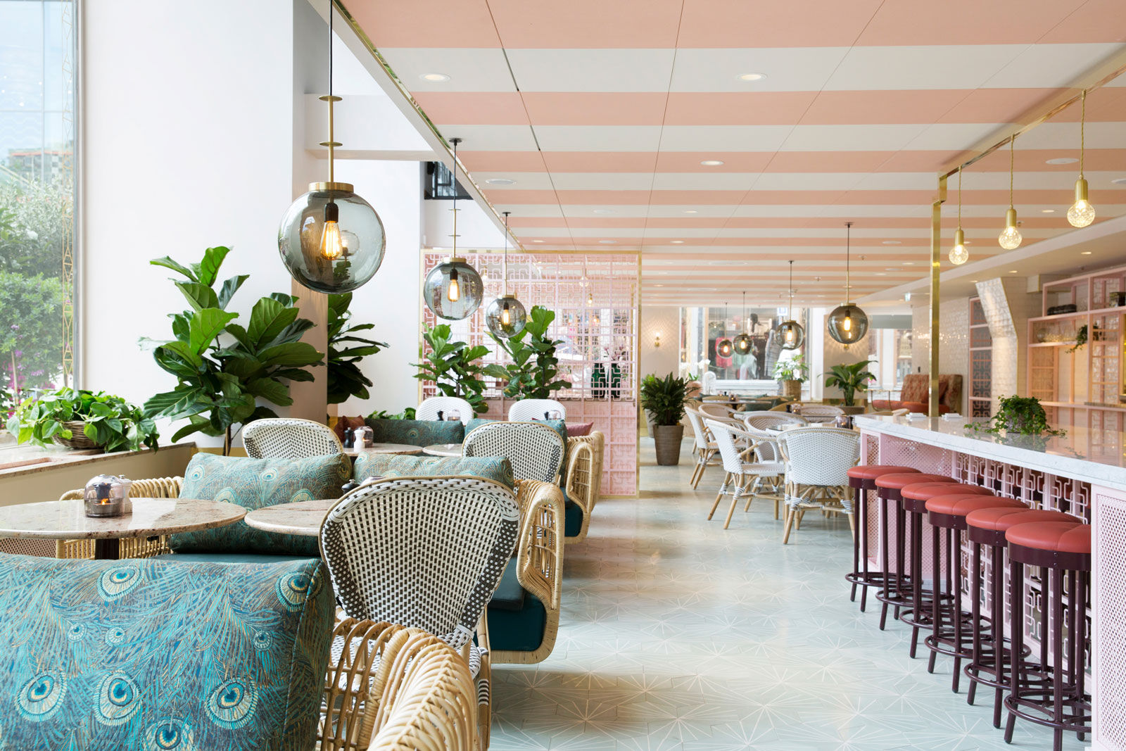 The café area of Scandic hotel is decorated with soft pink paired with peacock feather prints - Beautiful Homes