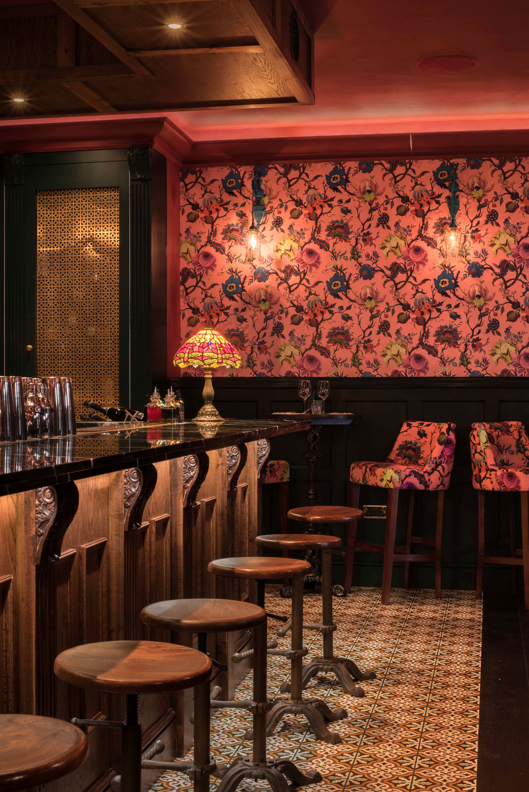 Bold wallpaper combined with antique furniture and Victorian tiles