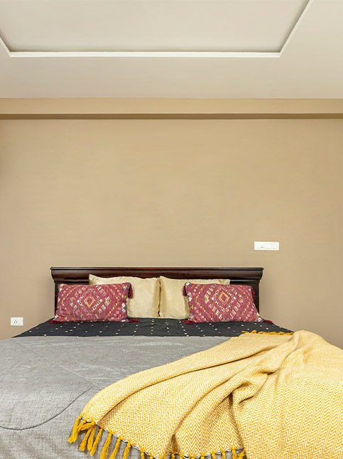 Light brown bedroom with bright red cushions