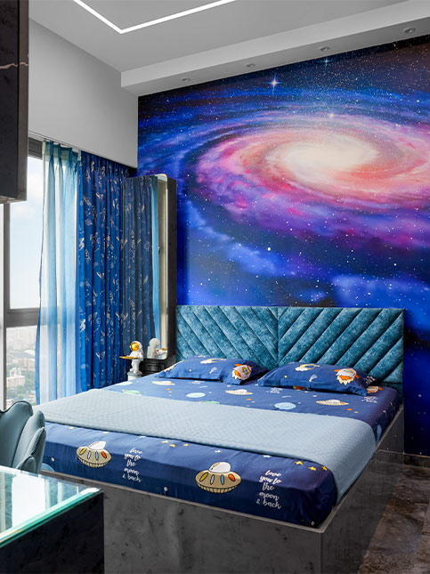 A galaxy themed wallpaper behind the bed