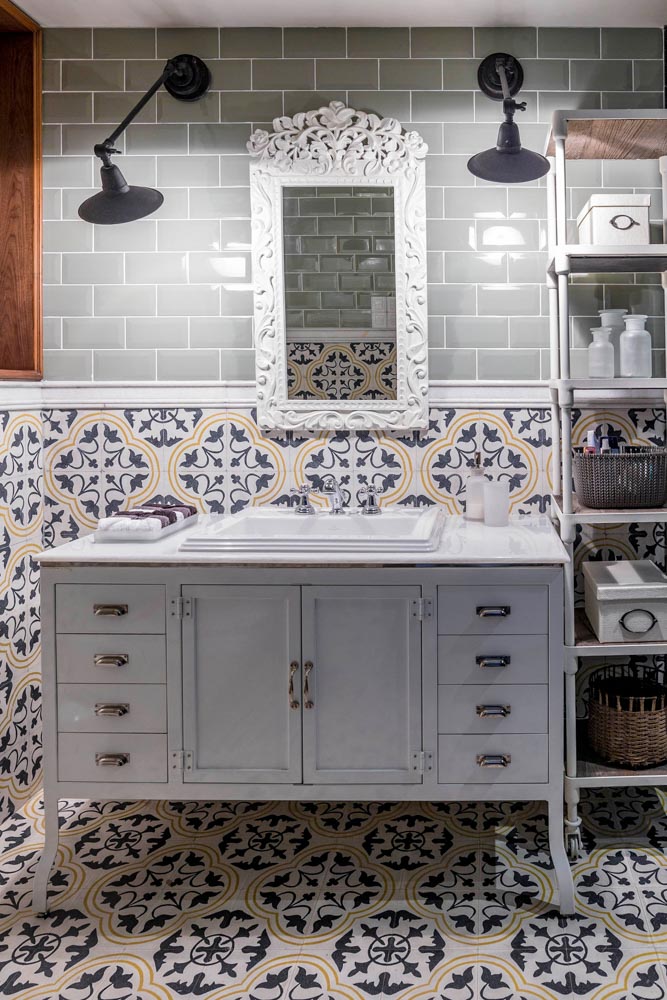 Bathroom of bohemian allure in a pastel shade of green with an open shelve unit for storage