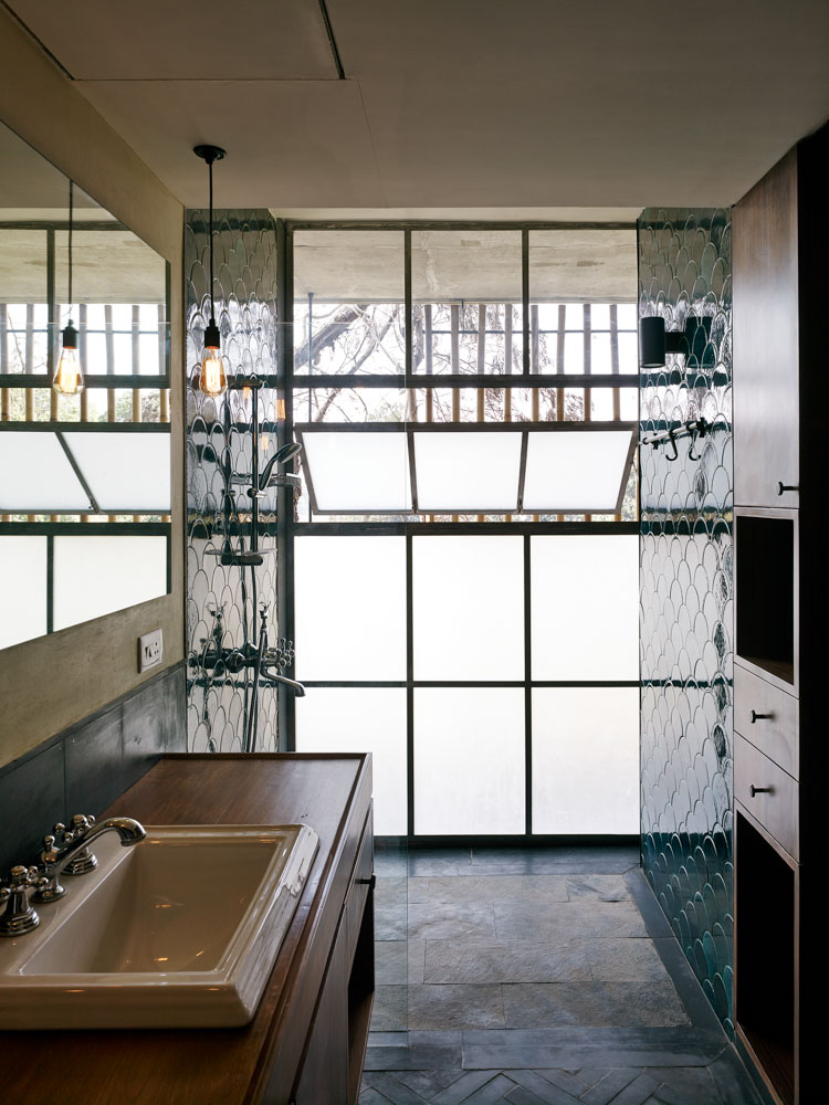 Dark and small bathroom with big window and no clutter, single hanging lamp as décor