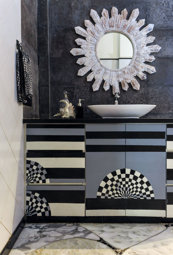 Bathroom in black, white and grey with mother of pearl mirror frame and chequered cabinets